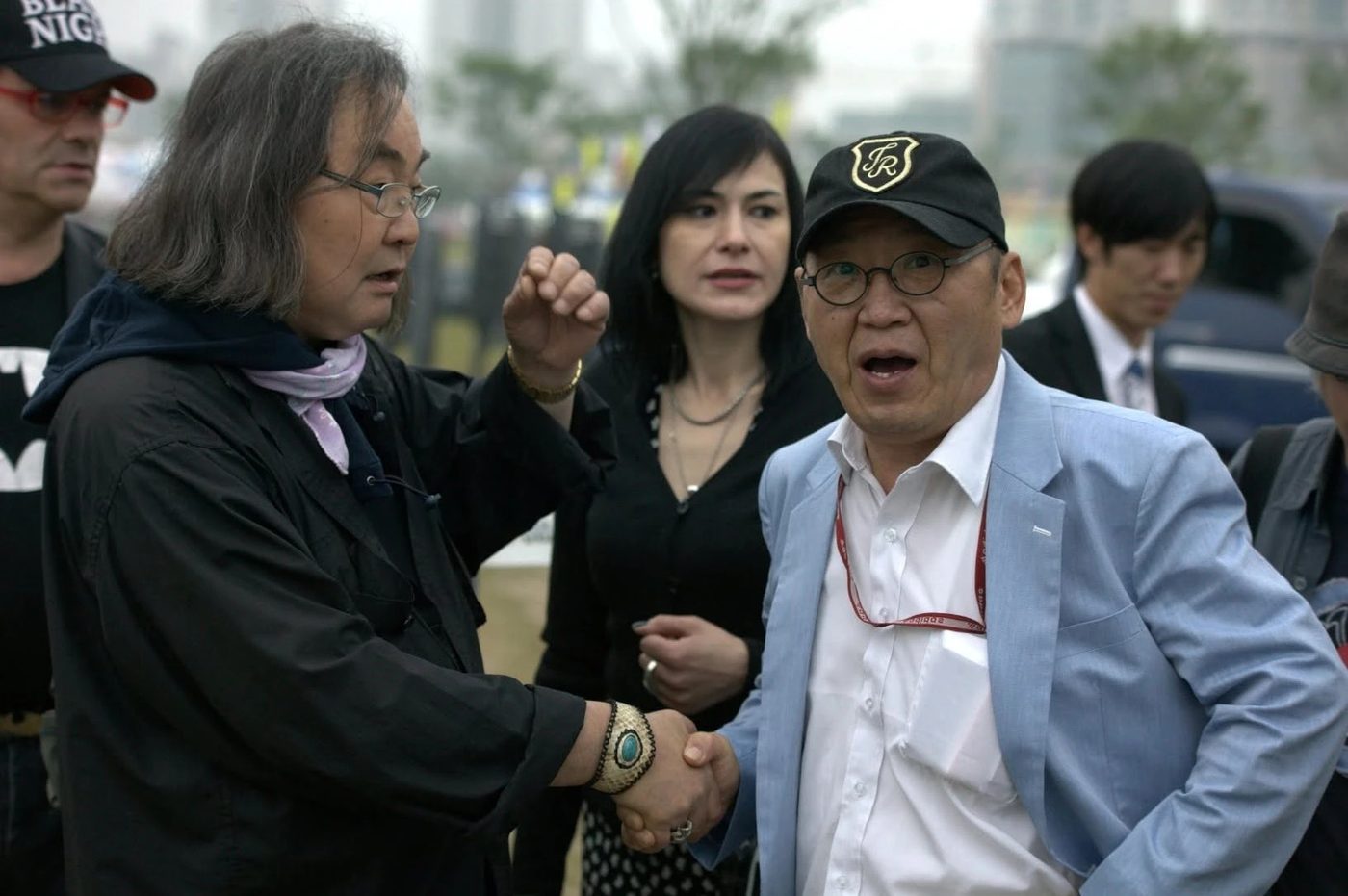 야외 행사장에서 반갑게 악수하는 한대수